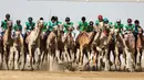Para joki memacu untanya dalam balap unta selama festival warisan Sheikh Sultan Bin Zayed al-Nahyan di Abu Dhabi, Uni Emirat Arab (10/2). (AFP/Karim Sahib)