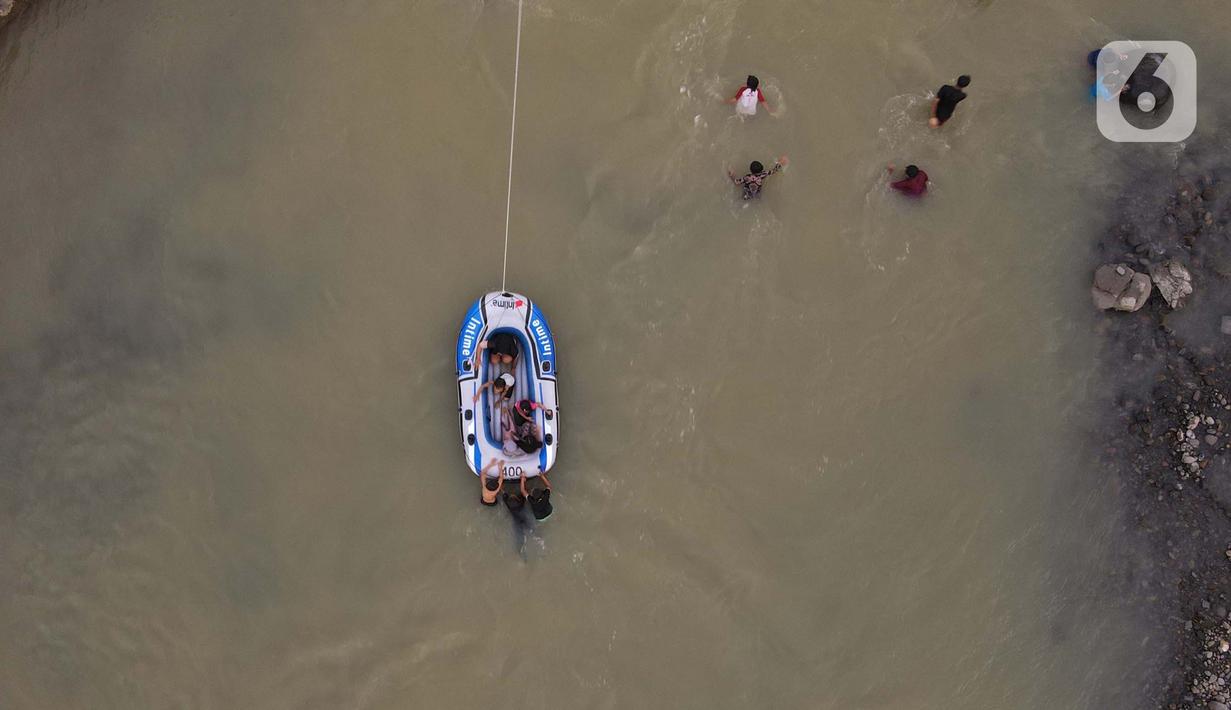 <p>Wisatawan menaiki perahu karet di aliran sungai Cipamingkis Kecamatan Sukamakmur, kabupaten Bogor, Jawa Barat, Kamis (5/5/2022). Warga memanfaatkan aliran sungai tersebut sebagai sarana hiburan Hari Raya Idul Fitri 1443 Hijriah. (merdeka.com/Imam Buhori)</p>