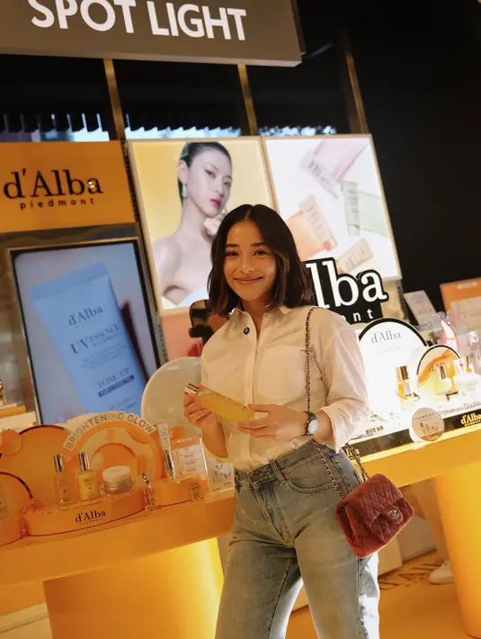 Ibu dua anak itu tampil simple dengan setelan semi formal kemeja putih lipat lengan dan celana jeans [@nikitawillyofficial94]