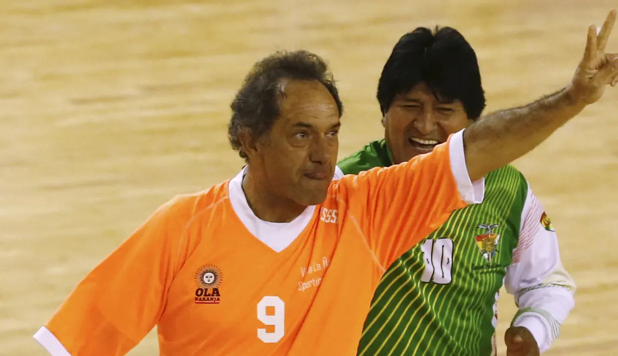 Evo Morales (kanan) tersenyum melihat Calon Presiden Argentina, Daniel Scioli (kiri) melakukan selebrasi usai mencetak gol saat pertandingan melawan tim Presiden Bolivia di Benavidez, Argentina (17/9/2015). (REUTERS/Marcos Brindicci)