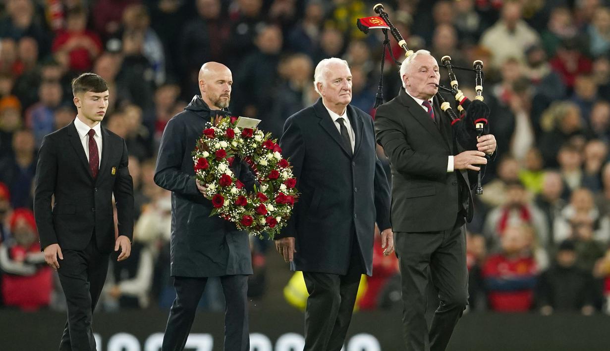 Pelatih manchester United, Erik ten Hag (kedua kiri) di dampingi mantan pemain MU, Alexander Stepney (kedua kanan) dan pemain Akademi MU, Dan Gore membawa karangan bunga untuk diletakkan di tengah lapangan untuk mengenang wafatnya legenda klub, Sir Bobby Charlton, sebelum dimulainya laga matchday ketiga Grup A Liga Champions 2023/2024 antara Manchester United menghadapi FC Copenhagen di Old Trafford Stadium, Rabu (25/10/2023) dini hari WIB. (AP Photo/Dave Thompson)