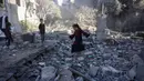 Seorang anak perempuan berjalan di atas puing-puing saat warga Palestina memeriksa lokasi serangan Israel semalam, di Jabalia, Jalur Gaza tengah, pada 30 Mei 2025. (Bashar TALEB/AFP)