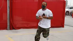 Pembalap Mercedes Lewis Hamilton tiba di paddock pada latihan bebas pertama di Sirkuit Internasional Formula 1 Bahrain, Sakhir, Bahrain, Jumat (27/11/2020). Lewis Hamilton dinyatakan positif COVID-19. (Hamad Mohammed, Pool via AP, File)