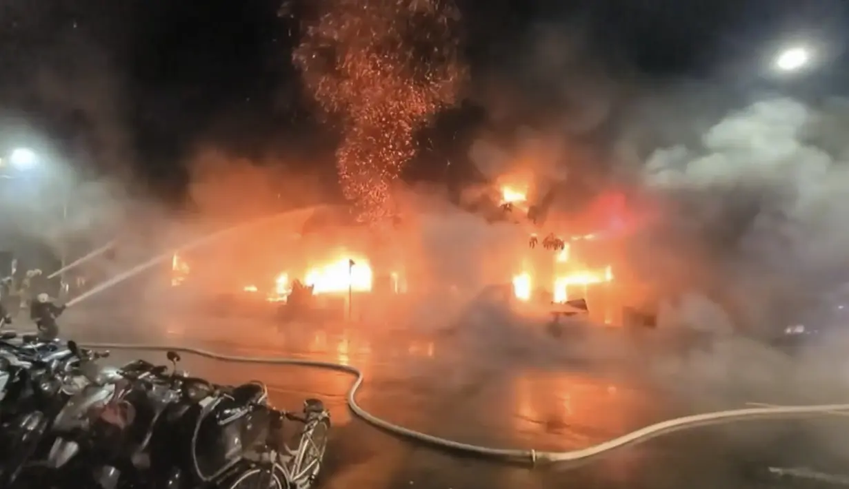 Petugas pemadam kebakaran memadamkan api di sebuah gedung di Kaohsiung, Taiwan selatan, Kamis (14/10/2021). Sedikitnya 46 orang tewas dan puluhan lainnya terluka parah dalam kebakaran di blok menara 13 lantai di Taiwan selatan, kata para pejabat. (EBC via AP )