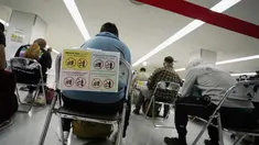 Penumpang duduk dan menunggu giliran selama proses karantina pencegahan virus corona setelah mendarat di Bandara Internasional Narita di Narita, timur Tokyo, Jepang (2/12/2021). Kasus pertama varian baru Covid-19 Omicron terdeteksi di Bandara Narita, Jepang.  (AP Photo/Hiro Komae)