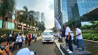 Direktur Utama Bank Syariah Indonesia, Hery Gunardi mengibarkan bendera dalam acara pelepasan pemudik disabilitas di Jakarta, Jumat (5/4/2024). Foto: Liputan6.com/Ade Nasihudin.