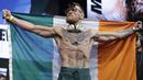 Conor McGregor membentangkan bendera Irlandia saat timbang badan jelang melawan Floyd Mayweather di Las Vegas (25/8/2017). McGregor akan bertarung 26 agustus 2017. (AP/John Locher)