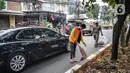 Warga menyapu jalan saat terkena razia masker di kawasan Karang Tengah Raya, Lebak Bulus, Jakarta, Senin (14/9/2020). Penertiban terkait pelaksanaan PSBB Jakarta kembali dan memutus rantai penyebaran COVID 19. (Liputan6.com/Faizal Fanani)