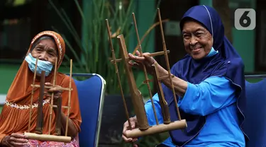 Para lansia mengikuti latihan angklung di Rumah Rehabilitasi Psikososial Dinas Sosial Kota Tangerang, Banten, Rabu (19/5/2021). Kegiatan berlatih angklung bagi lansia tersebut guna mengisi waktu luang sekaligus melatih motorik, auditori, dan sensorik para lansia. (Liputan6.com/Angga Yuniar)