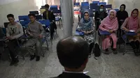 Mahasiswa dan mahasiswi menghadiri kelas yang dipisahkan dengan tirai di sebuah universitas swasta di Kabul, Afghanistan, Selasa (7/9/2021). Universitas di Afghanistan memisahkan pria dan wanita dalam kelas dengan tirai untuk mengikuti keputusan Taliban. (AAMIR QURESHI/AFP)