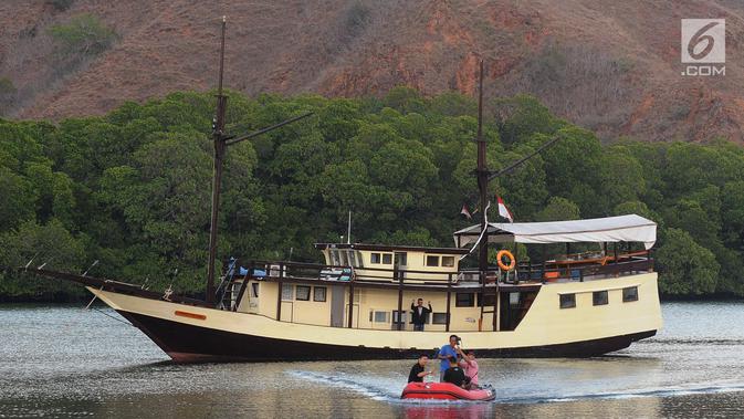 Wisatawan menaiki perahu karet saat mengarungi sebuah teluk di Pulau Rinca, Taman Nasional Komodo, NTT, Minggu (14/10). Pulau Rinca dapat dicapai dengan perahu kecil dari Labuan Bajo di Flores barat. (Merdeka.com/Arie basuki)