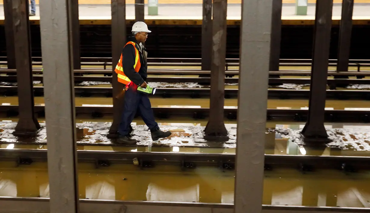 Pekerja memeriksa stasiun kereta bawah tanah Lincoln Center yang banjir di New York, Amerika Serikat, Senin (13/1/2020). Genangan air menghambat layanan kereta bawah tanah pada jam sibuk. (AP Photo/Richard Drew)