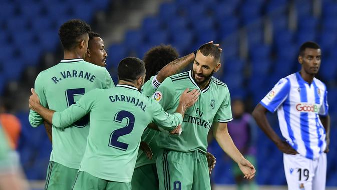 Striker Real Madrid Karim Benzema dan rekan-rekannya merayakan gol ke gawang Real Sociedad dalam lanjutan Liga Spanyol di Anoeta stadium, San Sebastian, Senin (22/6/2020) dini hari WIB.(AP Photo/Alvaro Barrientos)