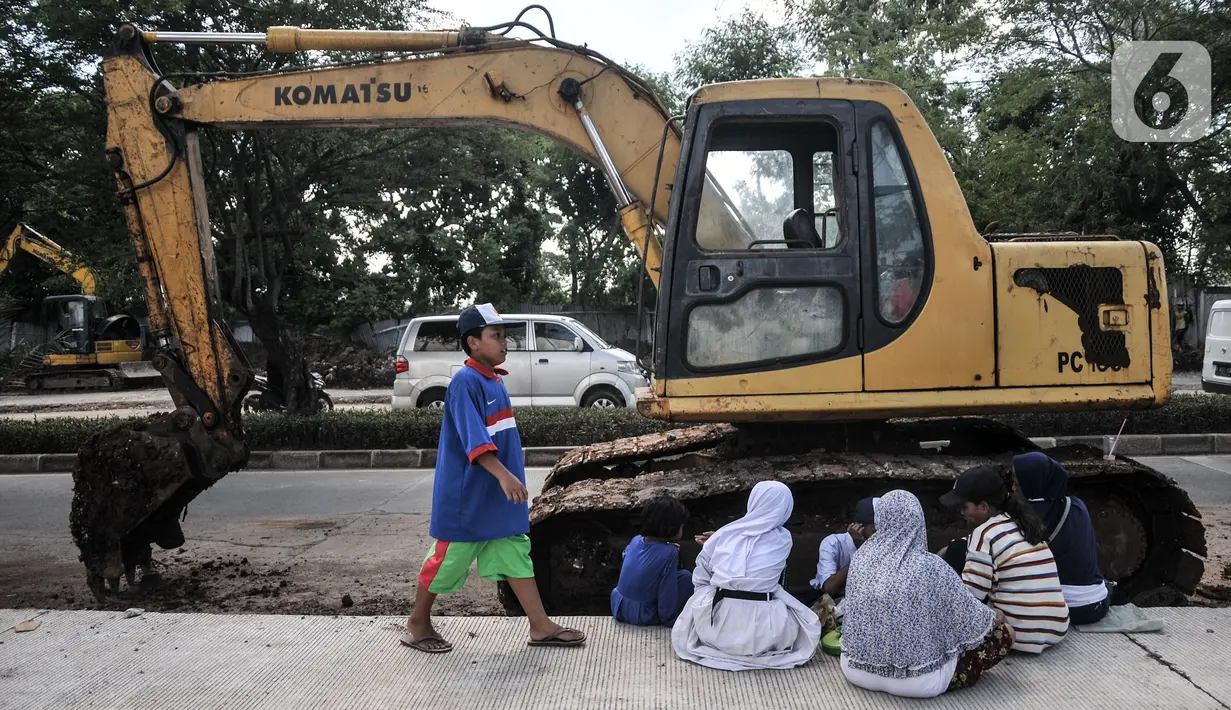 Warga duduk dekat alat berat saat berunjuk rasa di depan gerbang Kampung Susun Bayam, Jakarta Utara, Senin (21/11/2022). Aksi tersebut dilakukan untuk menagih janji PT Jakpro dan Pemprov DKI Jakarta agar warga bisa segera menempati Kampung Susun Bayam secepatnya. (merdeka.com/Iqbal S. Nugroho)