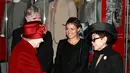Ini adalah Yoko Ono di tahun 2011 saat ia bertemu dengan Ratu Elizabeth. Yoko Ono mengenakan setelan serba hitam dengan topi yang serasi, serta sarung tangan putih. Foto: Website.