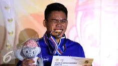 Karateka Jawa Barat, Rahmad menggigit medali usai memenangi laga final Kata Putra Perorangan PON XIX di GOR Sabuga, Bandung, Minggu (18/9). Di final, Rahmad berhasil mengungguli karateka Jambi, Erlando Stevano. (Liputan6.com/Helmi Fithriansyah)