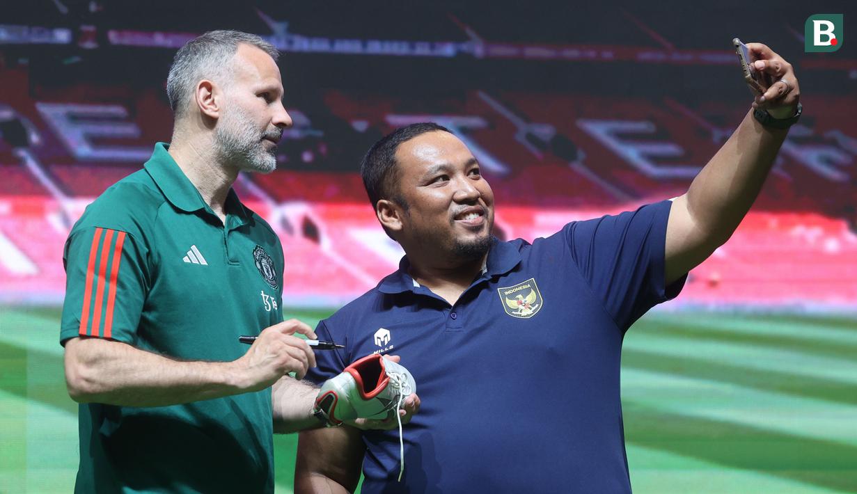 Fans swafoto bersama legenda Manchester United (MU), Ryan Giggs, dalam acara peluncuran kartu kredit Maybank yang berkolaborasi dengan MU di Jakarta Convention Center (JCC), Senayan, Jakarta, Sabtu (18/5/2024). (Bola.com/M Iqbal Ichsan)