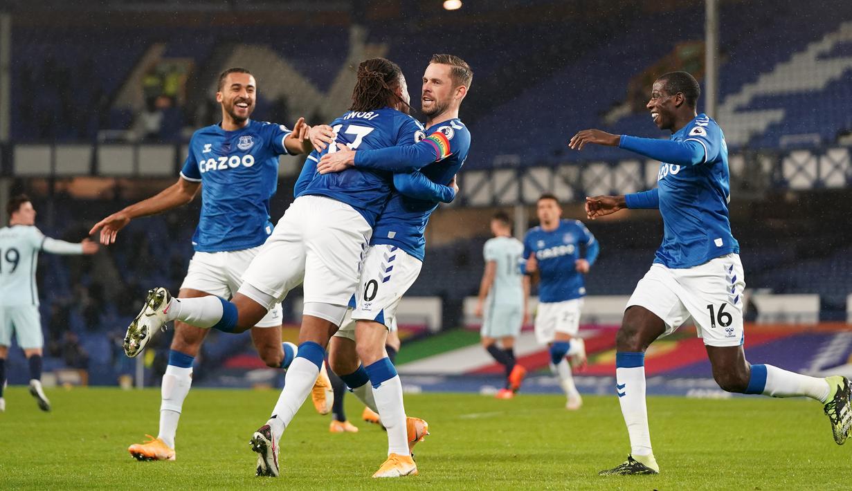 Gelandang Everton, Gylfi Sigurdsson (tengah), melakukan selebrasi bersama rekan-rekannya usai mencetak gol ke gawang Chelsea lewat eksekusi penalti dalam laga lanjutan Liga Inggris 2020/21 pekan ke-12 di Goodison Park Stadium, Sabtu (12/12/2020). Everton menang 1-0 atas Chelsea. (AFP/Jon Super/Pool)