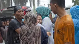 Keluarga korban menangis histeris saat jenazah diambil dari reruntuhan bangunan di daerah yang terkena gempa bumi di Mamuju, Sulawesi Barat, Jumat (15/1/2021). Setidaknya 34 orang meninggal dunia akibat gempa dahsyat tersebut. (AP Photo/Yusuf Wahil)
