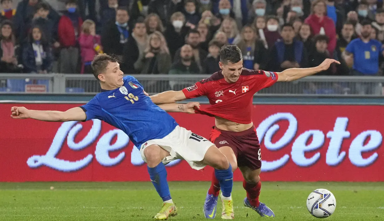 Gelandang Italia, Nicola Barella berebut bola dengan pemain Swiss, Remo Freuler pada pertandingan Grup C kualifikasi Piala Dunia 2022 di stadion Olimpiade Roma, Sabtu (13/11/2021). Hasil ini membuat Italia masih kokoh di puncak klasemen dengan 15 poin. (AP Photo/Gregorio Borgia)