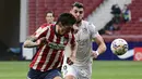 Bek Atletico Madrid, Stefan Savic (kiri) berebut bola dengan striker SD Huesca, Rafa Mir dalam laga lanjutan Liga Spanyol 2020/2021 pekan ke-32 di Wanda Metropolitano Stadium, Madrid, Kamis (22/4/2021). Atletico menang 2-0 atas SD Huesca. (AFP/Javier Soriano)