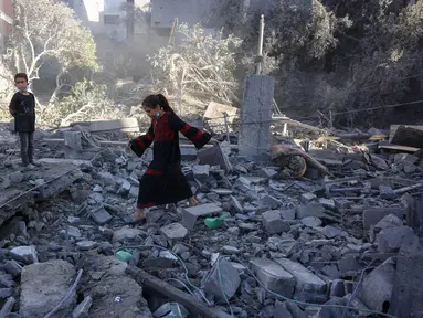 Seorang anak perempuan berjalan di atas puing-puing saat warga Palestina memeriksa lokasi serangan Israel semalam, di Jabalia, Jalur Gaza tengah, pada 30 Mei 2025. (Bashar TALEB/AFP)