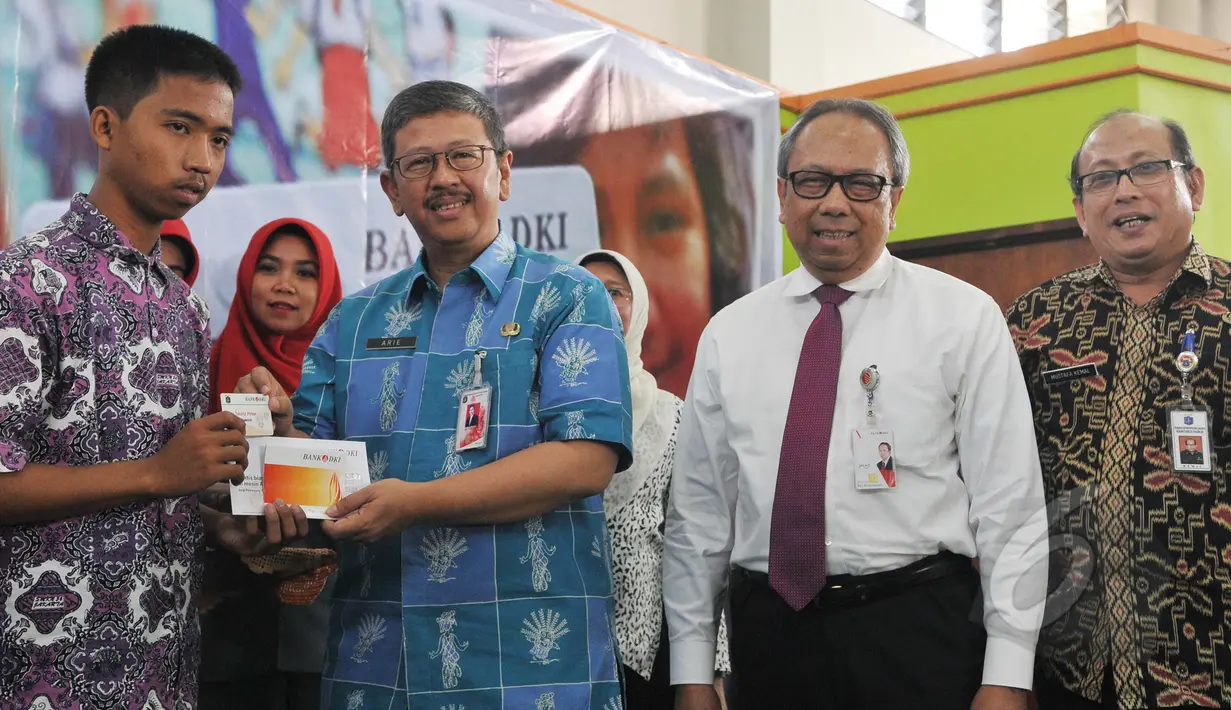 Kepala Dinas Pendidikan Arie Budhiman (kedua kiri) bersama Direktur Utama Bank DKI Eko Budiwiyono (kedua kanan) secara simbolis memberikan Kartu Jakarta Pintar (KJP) di SMK 56 Pluit, Jakarta, Kamis (21/5/2015). (Liputan6.com/Herman Zakharia)
