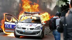 Sebuah mobil polisi terbakar saat demonstrasi buruh di Paris, Prancis (18/5). Demo buruh tersebut menentang kekerasan polisi dan melawan reformasi hukum yang berakhir bentrok dengan polisi. (REUTERS / Charles Platiau)