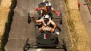 Peserta melintasi jalanan menurun dalam ajang balap mobil 'Kotak sabun' Red Bull Soapbox di Santiago, Chili, Minggu (27/11). Para pengemudi mengandalkan gaya gravitasi bumi karena kendaraan mereka tidak memiliki mesin. (REUTERS/Jonathan Faus)