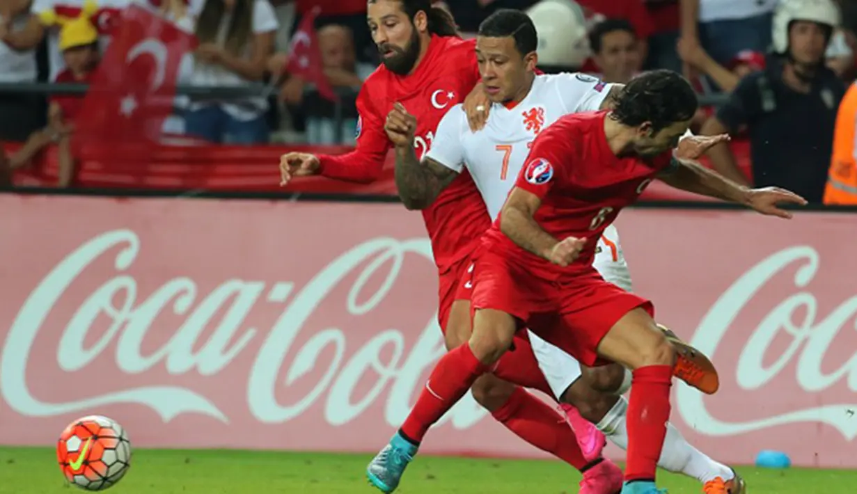 Penyerang Belanda, Memphis Depay (tengah) berusaha melewati dua pemain Turki pada kualifikasi Grup A Euro 2016 di Konya, Turki, (6/9/2015). Turki menang atas Belanda dengan skor 3-0. (AFP PHOTO/Stringer)