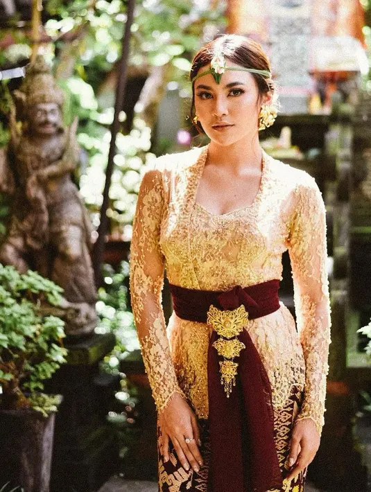 Mahalini tampil memesona dalam balutan baju adat Bali. Kebaya super cantik bernuansa keemasan ini, dipadunya dengan kain tenun sebagai bawahan, dan selendang berwarna cokelat, diberi tambahan detail bros, anting, dan hiasan kepala dan rambut, membuatnya tampil bak putri raja Bali. Foto: Instagram.