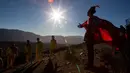 Seorang pemuda berpakaian sebagai dukun tiba untuk mengambil bagian dalam sesi foto sebelum gerhana matahari total di La Higuera, Chile (1/7/2019). Gerhana matahari total akan terjadi pada 2 dan 3 Juli di Pasifik dan Amerika Selatan. (AP Photo/Esteban Felix)