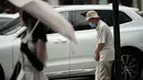 Seorang pria yang mengenakan masker pelindung untuk membantu mengekang penyebaran virus corona menunggu lampu lalu lintas di distrik perbelanjaan Ginza di Tokyo, Selasa (1/9/2020). Ibukota Jepang mengonfirmasi lebih dari 170 kasus virus korona pada hari Selasa. (AP Photo/Eugene Hoshiko)