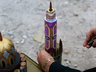 Seniman Suriah, Akram Abu Elfoz (37) memberikan sentuhan akhir pada replika Masjid Al-Rawdah yang dibuat dari selongsong peluru dan sisa amunisi perang, di sebelah timur Suriah, Ibu Kota Damaskus, 3 Juni 2016.  (AFP PHOTO/Sameer Al - Doumy) 