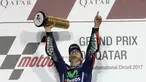 Pembalap Movistar Yamaha MotoGP, Maverick Vinales, mengangkat pialanya di atas podium setelah memenangi MotoGP Qatar di Sirkuit Losail, Doha, Minggu (26/3). Vinales menyelesaikan balapan dengan catatan waktu 38 menit 59,999 detik. (Karim JAAFAR/AFP)