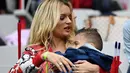 Ludivine Payet menggendong anaknya saat menonton suaminya Dimitri Payet bersama tim Prancis melawan Islandia pada perempat final Piala Eropa 2016 di Stade de France, Saint-Denis, Paris. (4/7/2016) dini hari WIB. (AFP/Franck Fife)
