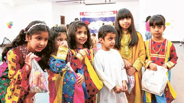Anak-anak bernyanyi untuk permen di Uni Emirat Arab.