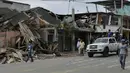 Warga melewati reruntuhan bagunan pasca gempa berkekuatan 7,8 yang melanda Pedernales, Ekuador, Minggu (17/4). Tim penyelamat menggunakan traktor dan tangan kosong untuk mencari para korban lainnya yang terkubur puing-puing bangunan. (RODRIGO Buendia/AFP)