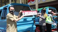 Pjs Gubernur Sulut Agus Fatoni bersama Kapolda Sulut Irjen Pol RZ Panca Putra memsang stiker ajakan mengenakan masker.