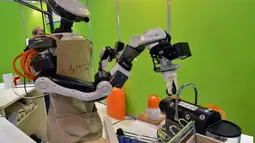Sebuah robot bernama Nextage sedang memperlihatkan kemahirannya membuat secangkir kopi di depan para pengunjung dalam sebuah pameran Robot Week di Tokyo, Jepang, Rabu (15/10) (AFP PHOTO/Yoshikazu Tsuno)