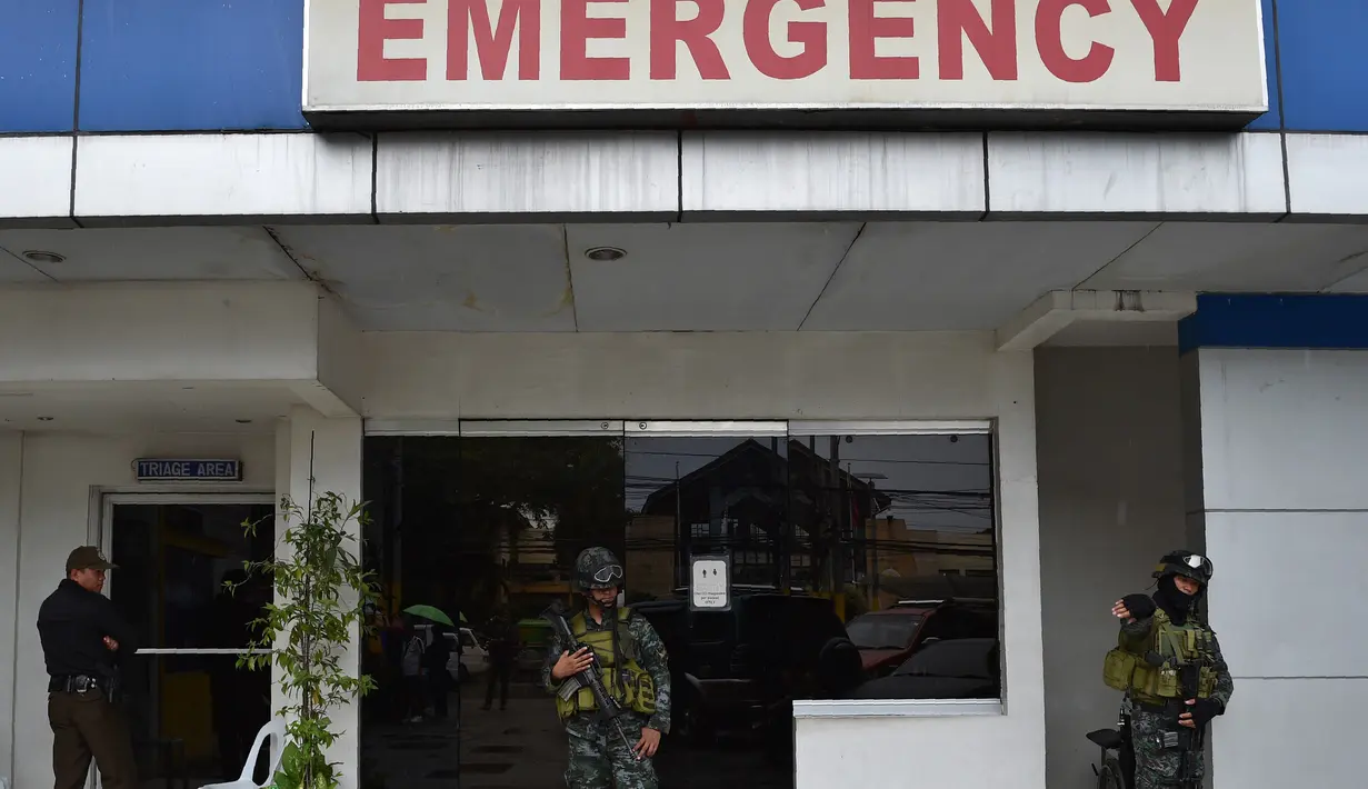 Sejumlah polisi pasukan khusus berjaga di pintu masuk gawat darurat menyusul kerusuhan yang terjadi di sebuah penjara di Filipina, Rabu (28/9). Selain menewaskan satu anggota geng narkoba, kerusuhan itu juga melukai tiga napi lainnya. (TED Aljibe/AFP)