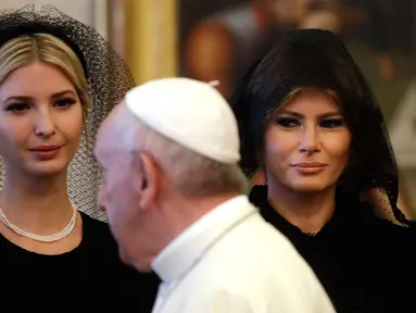 Paus Fransiskus berjalan melewati Ivanka dan Ibu Negara AS, Melania Trump pada pertemuan pribadi bersama Presiden Donald Trump di Vatikan, (24/5). Melania dan Ivanka mengenakan penutup kepala hitam saat menemui Paus. (AP Photo/Alessandra Tarantino, Pool)