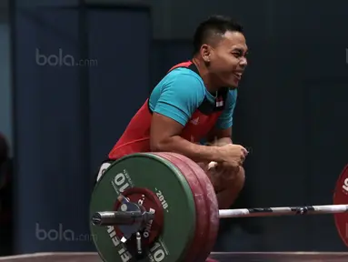 Senyum Lifter Indonesia, Eko Yuli Irawan usai mengangkat beban 135 kg snacth saat turun pada kelas 62 kg di Hall A Arena PRJ, Jakarta, Rabu (11/2/2018). Eko berhasil menyabet medali emas. (Bola.com/Nicklas Hanoatubun)