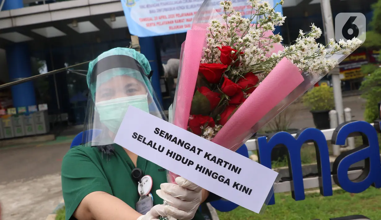 Tenaga medis menunjukkan bunga mawar dan ucapan selamat Hari Kartini di RSUD Kota Tangerang, Selasa (21/4/2020). Komunitas Taman Potret memberikan bunga dan APD kepada tenaga medis perempuan sebagai bukti pemberian semangat kepada mereka yang merupakan Kartini Masa Kini. (Liputan6.com/Angga Yuniar)
