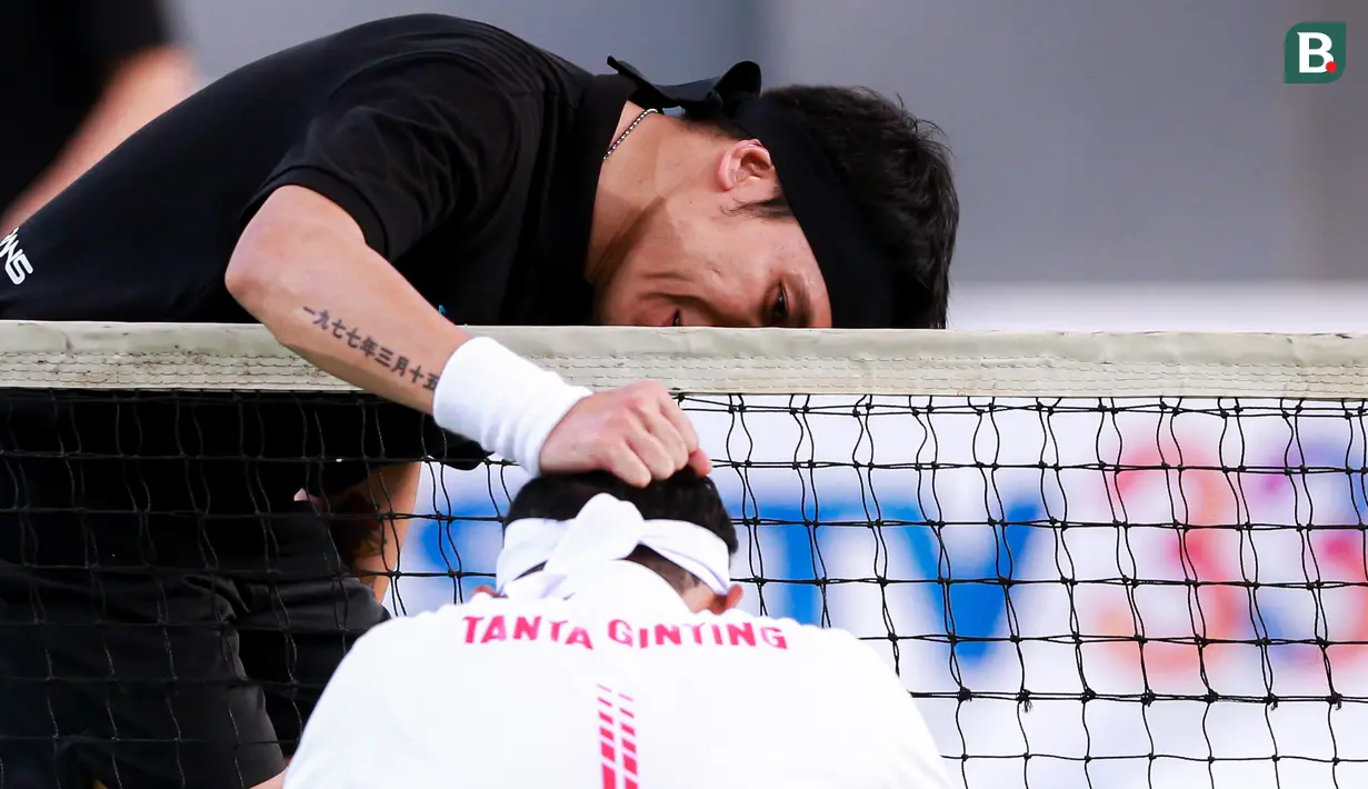 Selebritas Indonesia, Deddy Mahendra Desta mengusap kepala Tanta Ginting pada laga tenis nomor ganda putra Turnamen Olahraga Selebriti Indonesia di GOR UNJ, Jakarta, Minggu (30/07/2023). Desta yang berpasangan dengan Raffi Ahmad menang dengan skor 4-6, 6-4, dan 6-4. (Bola.com/Bagaskara Lazuardi)