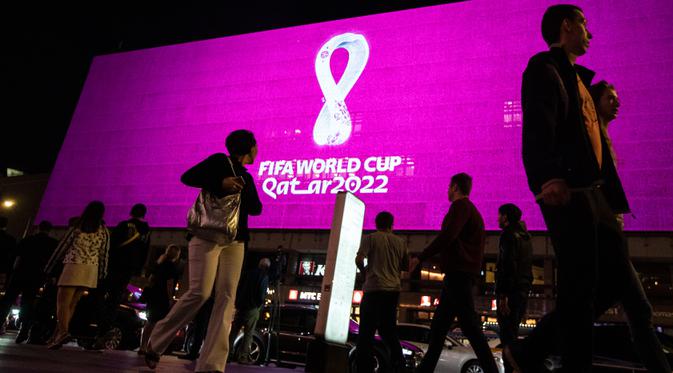 Orang-orang melintasi layar yang menampilkan logo Piala Dunia Qatar 2022, di jalanan New Arbat, pusat kota Moskow di Rusia, Selasa (3/9/2019). Logo tersebut ditampilkan di ruang publik di Qatar dan kota-kota besar seluruh dunia. (AP Photo/Pavel Golovkin)