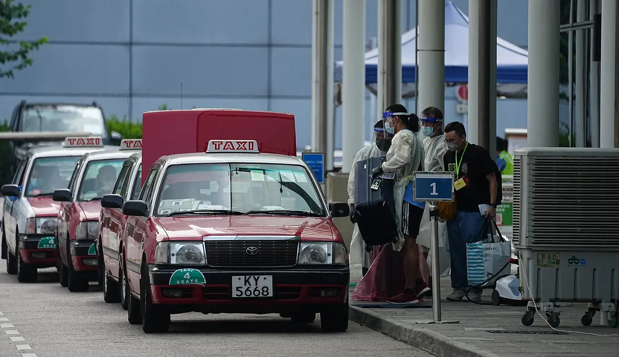 Penumpang memindahkan barang bawaan mereka ke taksi untuk pergi ke hotel karantina setelah tiba di bandara internasional Hong Kong di Hong Kong, Jumat (23/9/2022). Pada satu titik, kota itu memiliki salah satu periode karantina terpanjang di dunia pada 21 hari isolasi wajib. (AP Photo/Lam Yik)