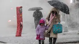 Pejalan kaki berjalan di sepanjang St. Delancey saat badai salju di New York (7/3). Badai salju kedua yang melanda New York dalam waktu seminggu ini diperkirakan akan membawa angin kencang. (AP Photo / Mary Altaffer)