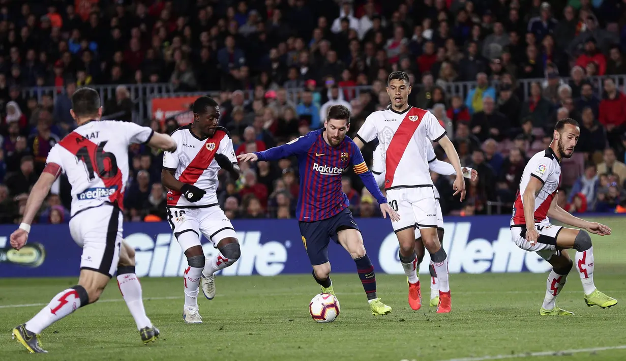 Striker Barcelona, Lionel Messi, berusaha melewati pemain Rayo Vallecano pada laga La Liga di Stadion Camp Nou, Sabtu (9/3). Barcelona menang 3-1 atas Rayo Vallecano. (AP/Manu Fernandez)