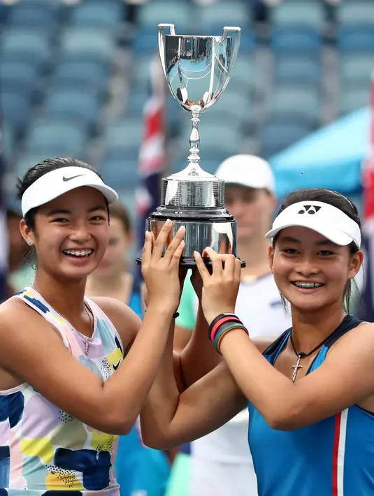 Alexandra Eala dari Filipina (kiri) dan Priska Madelyn Nugroho dari Indonesia berpose dengan piala usai mengalahkan Ziva Falkner (Slovenia)/Matilda Mutavdzic (Inggris) pada final Australia Terbuka Junior 2020 di Melbourne, Jumat (31/1/2020). Priska/Alexandra menang 6-1, 6-2. (AP/Dita Alangkara)